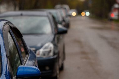 Kirli yolun kenarına park edilmiş arabalar - seçici odaklı telefoto yakın plan