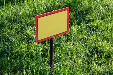 Yeşil çimenlik arka planda boş sarı işaret modeli - seçici odaklı yakın plan