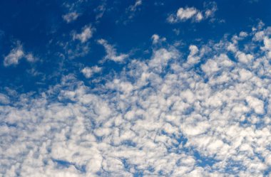 Mavi gökyüzünde beyaz akşam altocumulus bulutları tam çerçeve arkaplan