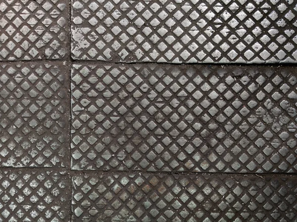 old cast iron factory floor tiles with checkered skid-proof pattern