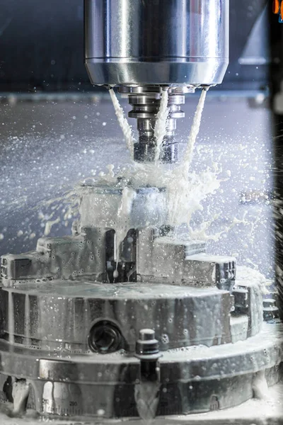 Vertikale Aufnahme des industriellen Nassfräsprozesses in einer 5-Achs-CNC-Maschine mit Kühlmittelfluss unter Druck und gefrorenen Spritzern — Stockfoto