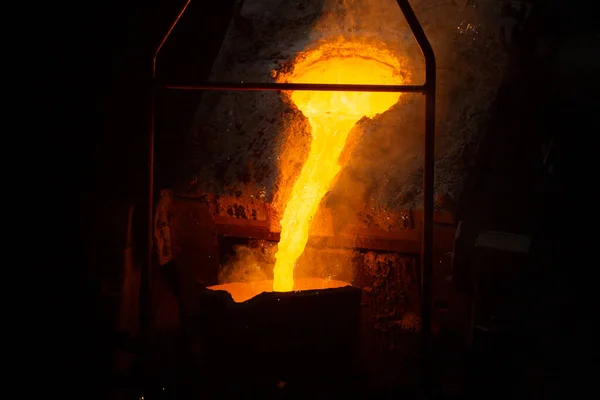 Un proceso de llenado de cucharón con acero caliente fundido del horno con humo: primer plano con enfoque selectivo — Foto de Stock