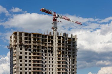Bulutlu arka planda vinci olan büyük bir apartman binası inşa süreci