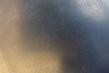 Birkaç küçük çizikle kaplanmamış, düz, yuvarlanmış çelik bir yüzey. Seçici odak ile yakın plan.