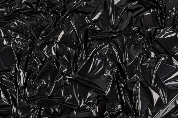 Buruşmuş siyah plastik film torbasının tam kare arkaplanı