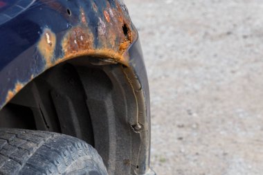 Mavi araba kanadında paslanmış seçici bir odak ile yakın plan.