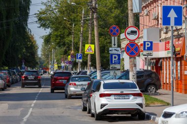 Tula, Rusya - 2 Ağustos 2021: Gün ışığında park halindeki birçok araçla birlikte dar şehir caddesi boyunca ezici trafik levhaları.