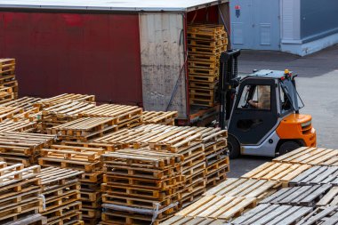 Forklift kullanılmış ahşap palet yığınlarını kamyona yüklüyor - yukarıdan perspektif görünümü