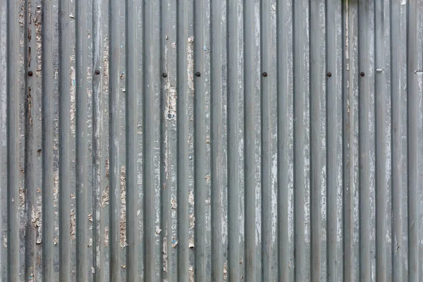 Corrugated zinc-plated sheet fence with paper advertisements leftovers — Stock Photo, Image