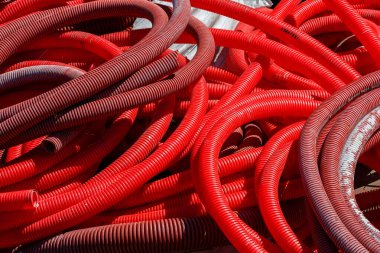 İnşaat alanında kırmızı kıvrımlı PVC borular vardı.