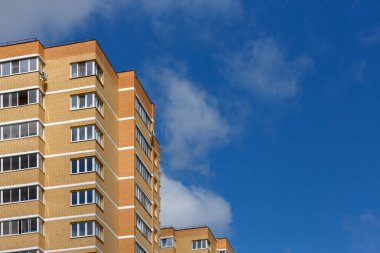 Güneşli gün ışığında sarı-turuncu tuğlalı apartman binaları, yakın plan telefoto manzarası.