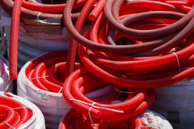 İnşaat alanında kırmızı kıvrımlı PVC borular vardı.