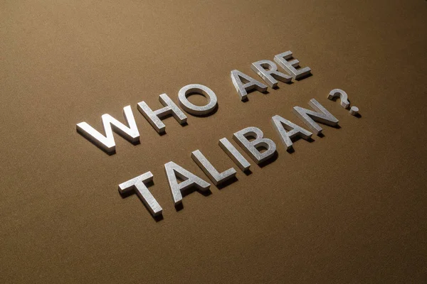Pytanie, kim są talibowie złożone srebrnymi metalowymi literami na surowej tkaninie płóciennej khaki tan — Zdjęcie stockowe