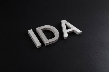 Kuru siyah mat yüzeyine gümüş metal harflerle 