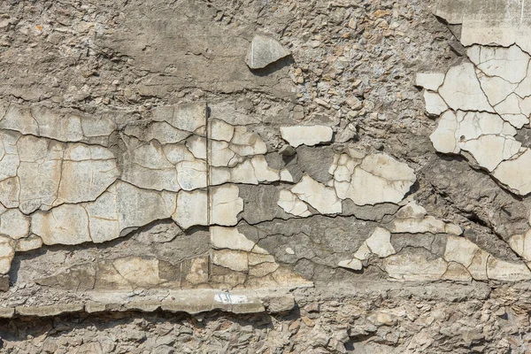 Doğrudan güneş ışığının altındaki çatlamış beton duvar tam çerçeve arkaplan ve doku
