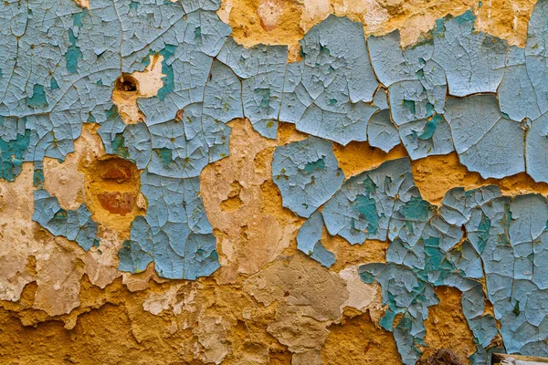黄砂灰泥壁上剥落的蓝色油漆。特写全框背景和纹理 — 图库照片