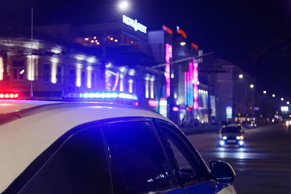 Luzes do carro da polícia na cidade noturna com foco seletivo e bokeh — Fotografia de Stock