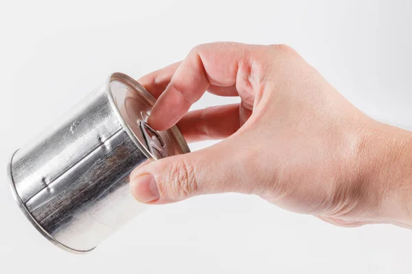 Bare caucasian hand opens a tin can with a pull ring on a white background — Stock Photo, Image