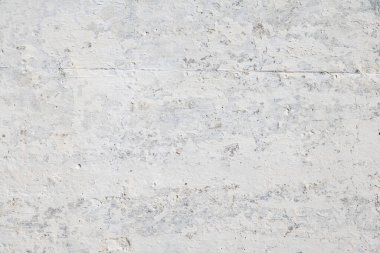 Rough and weathered wall texture with peeled paint renovated with whitewash over.