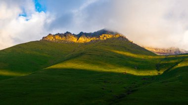 Serene mountain landscape showcases majestic peaks under clear blue sky. Dramatic scenery evokes feelings of peace and tranquility in nature.