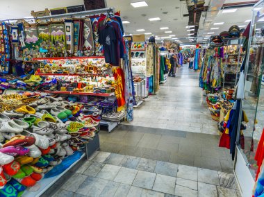Interior view of a vibrant souvenir section in the TSUM department store in Kyrgyzstan. Various traditional crafts and ethnic products are displayed on shelves and hangers. Bishkek, Kyrgyzstan - February 25, 2024