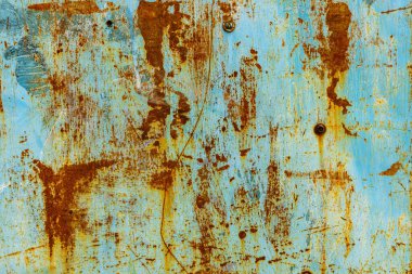 Close-up of a weathered turquoise blue metal surface with significant rust and corrosion
