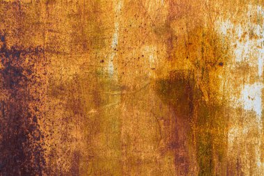 Extensive rust on a metal surface with vertical white paint leftovers and dark corrosion spots