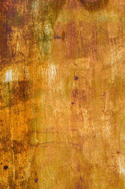 Extensive rust on a metal surface with vertical white paint leftovers and dark corrosion spots