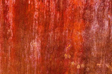 Uniformly rusted reddish-brown metal surface with vertical streaks of darker oxidation