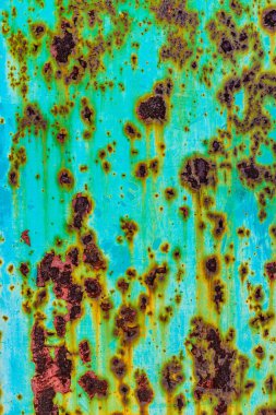 Extreme close-up of a turquoise metal surface with extensive rust formation and streaks down from rust spots