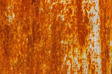 Heavily rusted metal texture. Deep orange and brown rust contrasts with remnants of light blue or gray paint. Uneven, dripping surface shows extensive corrosion and weathering.