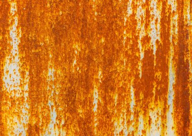 Heavily rusted metal texture. Deep orange and brown rust contrasts with remnants of light blue or gray paint. Uneven, dripping surface shows extensive corrosion and weathering.