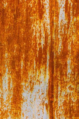 Heavily rusted metal texture. Deep orange and brown rust contrasts with remnants of light blue or gray paint. Uneven, dripping surface shows extensive corrosion and weathering.