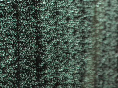 water drops on car window during the rain - closeup full-frame view with selective focus