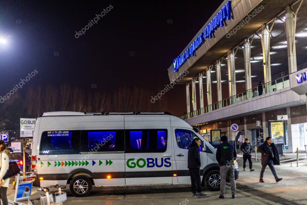 GoBus shuttle bus on Parking lot in front of Manas airport in Bishkek, Kyrgyzstan at night - March 18, 2024