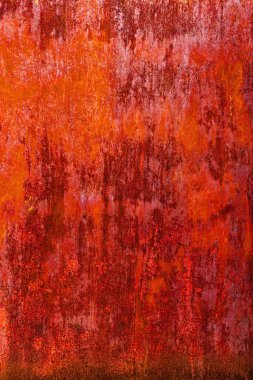 Uniformly rusted reddish-brown metal surface with vertical streaks of darker oxidation