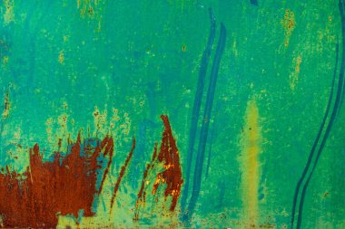 Close-up showing large patches of peeling green paint exposing the underlying orange-brown rust on a metal surface.