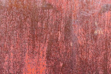 Worn red painted surface with scratches and discoloration, showing signs of age and use - Full-frame background and texture.