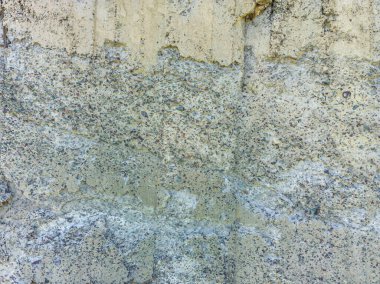 Yakından bakınca, dış katmanın ufalandığı beton bir duvar dokusu görünüyor. Bu da alttaki yığını ortaya çıkarıyor. Bu da inşaat kusuru ya da çimentoda ciddi bir yıpranma olduğunu gösteriyor..