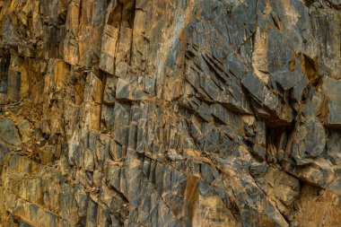 Gündüzleri dağlık bölgede engebeli kaya oluşumu görkemli bir şekilde duruyor. Dokulu yüzeyler ve pürüzlü hatlar dramatik bir açık hava manzarası yaratır, yalnızlık ve güç hissi uyandırır..