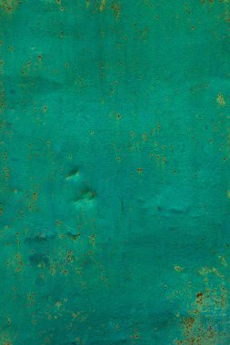 Teal metali boyamış ve dış sanayi ortamında paslanma belirtileri gösteriyor. Yıpranmış görünüş, gün ışığında yaşlılık ve kırsal bir cazibeyi çağrıştırıyor..