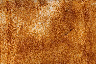 Paslı metal yüzey, endüstriyel bir açık hava ortamında doku ve yaşlanma gösteriyor. Pis atmosfer, gündüz vakti elementlere yıllarca maruz kalmayı yansıtıyor..