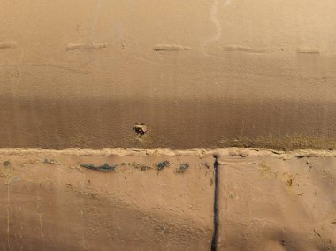 Kırsal bir metal yüzeyde aşınma, pas ve boya kırıntıları var. Gündüz vakti açık havada yakalanan eski dokular tarihin bir duygusunu uyandırıyor..