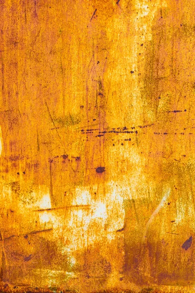 Extensive rust on a metal surface with vertical white paint leftovers and dark corrosion spots