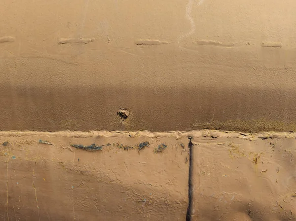 Kırsal bir metal yüzeyde aşınma, pas ve boya kırıntıları var. Gündüz vakti açık havada yakalanan eski dokular tarihin bir duygusunu uyandırıyor..