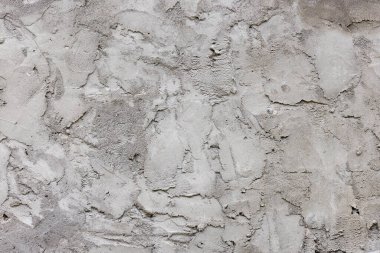 Gündüz vakti pürüzlü yüzeyi, dokusu ve arkaplanı olan gri kuru beton duvar..