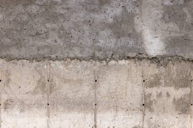 Yıpranmış beton duvar dış mekânda pürüzlü desen sergiliyor. Gündüz ışığı kırsal görünümü geliştirir ve mimari özellikleri vurgular.