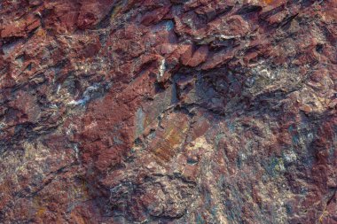 Sert desenli kırmızı tortulu kaya oluşumu tam kare yakın çekim görünümü.