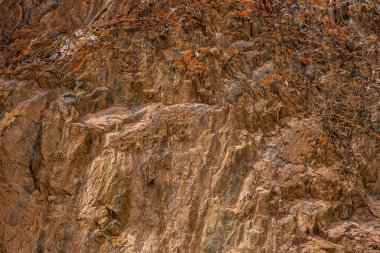 Dağlık bölgede dramatik kaya oluşumu görkemli bir şekilde yükseliyor. Topraksı dokular ve engebeli yüzeyler gün boyunca açık gökyüzü ile doğanın güzelliğini yansıtır..