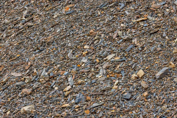 Kırgızistan 'da gündüz vakti kayalık yamaçta dağılmış, ezilmiş tortulu kayalar - tam kare arka plan